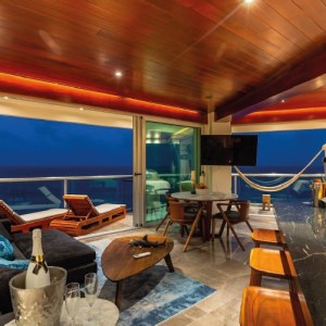 Luxury oceanfront living room at Villa Quarry Cancun with panoramic sea view, hammock, and modern wood ceiling | I Live Where You Vacation / Sala frente al mar en Villa Quarry Cancún con vista panorámica, hamaca y techo de madera moderna | I Live Where You Vacation