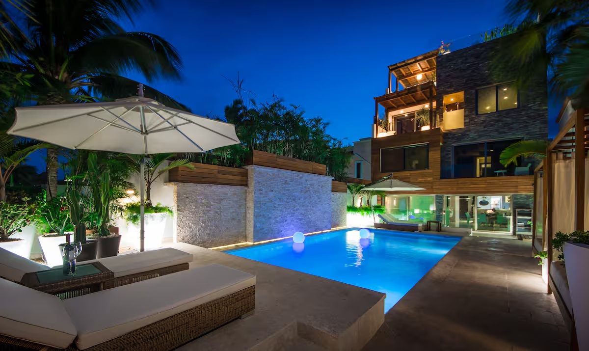 Villa Patrón’s pool area transforms into an enchanting oasis at night, where soft lighting, elegant design, and tropical ambiance create the perfect setting for relaxation or celebration. | El área de alberca de Villa Patrón se transforma al anochecer en un oasis encantador, con iluminación tenue, diseño elegante y una atmósfera tropical ideal para relajarse o celebrar.
