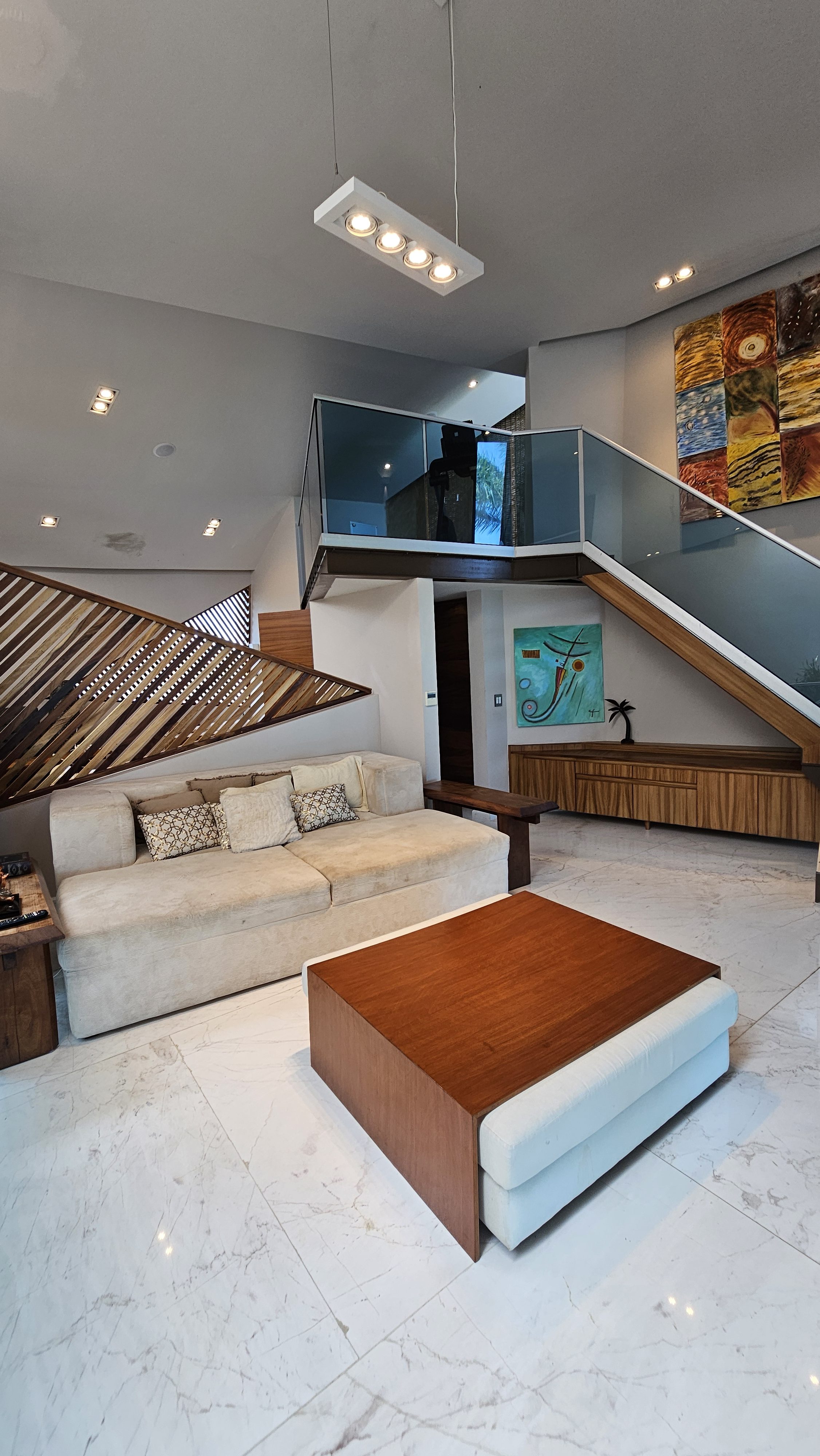Contemporary lounge area with elegant staircase and modern design — perfect blend of comfort and art in Cancun. | Área de descanso contemporánea con escalera elegante y diseño moderno — perfecta combinación de arte y confort en Cancún.
