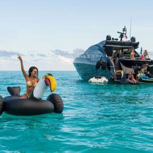 Guests enjoying water activities with the Truco 64 ft yacht in turquoise Caribbean waters – I Live Where You Vacation | Invitados disfrutando actividades acuáticas con el yate Truco 64 pies en aguas turquesa del Caribe – I Live Where You Vacation