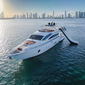 Aerial view of Truco VII 85 ft luxury yacht near Cancun skyline – I Live Where You Vacation | Vista aérea del yate de lujo Truco VII de 85 pies frente al skyline de Cancún – I Live Where You Vacation