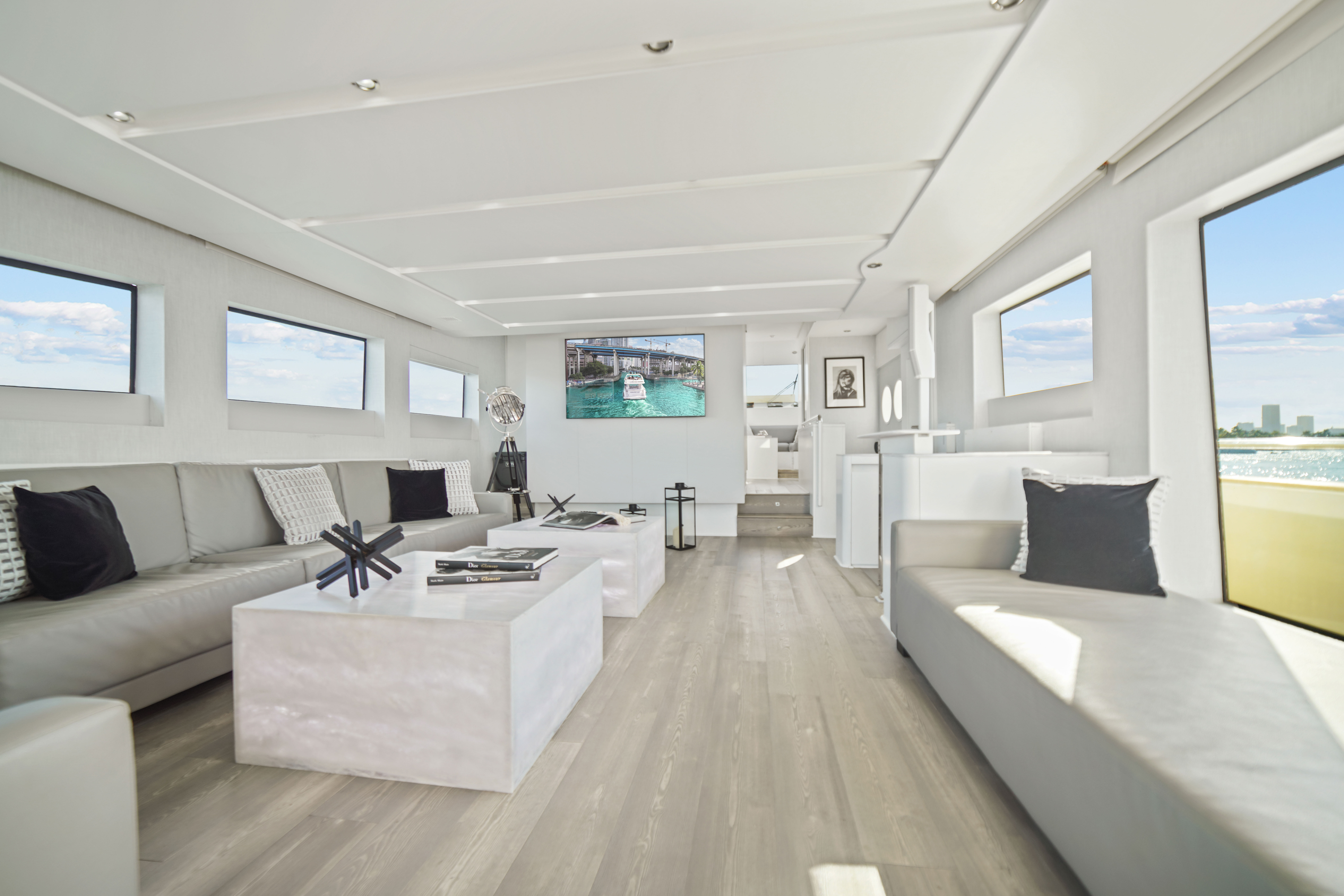 Inside the Truco VII 85 ft yacht, the main salon offers a sleek, modern atmosphere with natural light and 360° ocean views — a refined charter experience by I Live Where You Vacation. | En el interior del yate Truco VII de 85 pies, el salón principal ofrece una atmósfera moderna y luminosa con vistas de 360° al mar — una experiencia charter refinada de I Live Where You Vacation.

