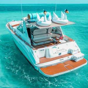 Seañorita 43 ft Sea Ray Sundancer yacht in turquoise Caribbean waters with inflatable swans on deck – I Live Where You Vacation | Yate Seañorita Sea Ray Sundancer de 43 pies en aguas turquesa del Caribe con inflables de cisnes en cubierta – I Live Where You Vacation