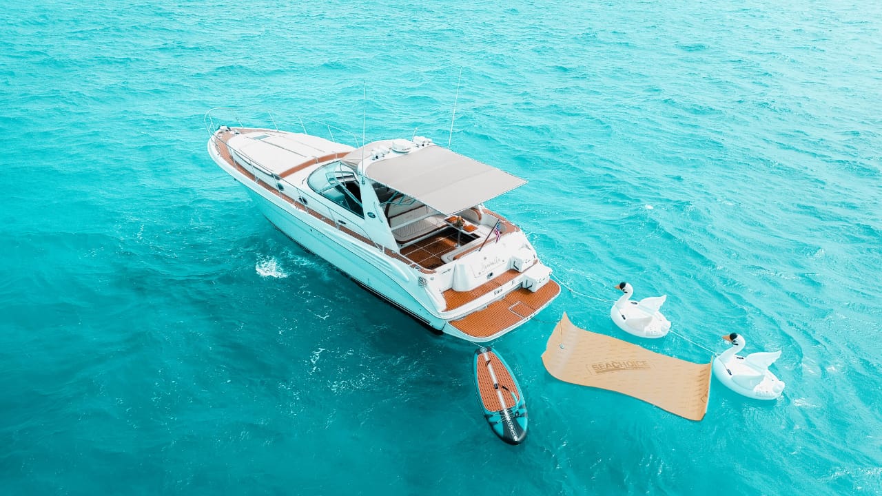 Seañorita anchored over the Caribbean — turquoise waters, swan inflatables, and paddleboards set the scene for pure island luxury. | El Seañorita anclado sobre el Caribe — aguas turquesa, inflables de cisne y paddleboards crean el escenario del lujo isleño perfecto.
