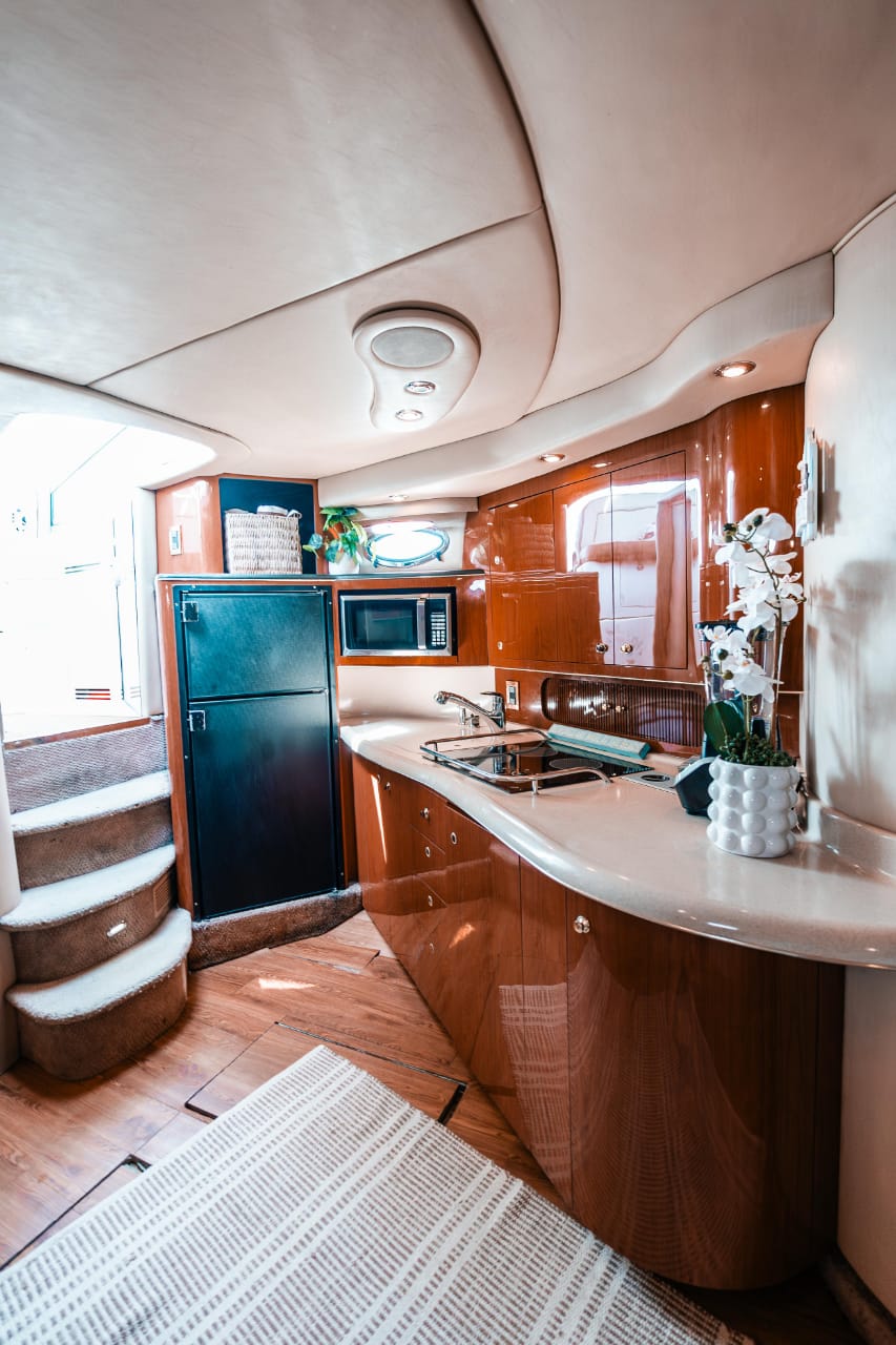 A sleek galley featuring cherry-wood cabinetry, built-in appliances, and elegant design — the Seañorita offers comfort and style at sea. | Una cocina elegante con gabinetes de madera cerezo, electrodomésticos integrados y diseño refinado — Seañorita ofrece confort y estilo en el mar.
