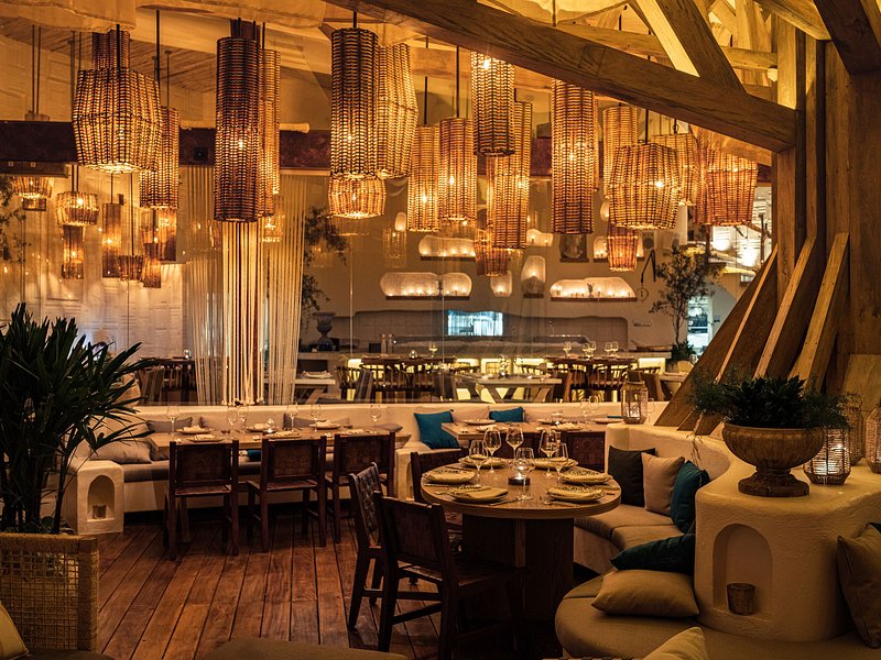 Luxury Mediterranean restaurant in Cancún with warm lighting and elegant décor by I Live Where You Vacation – fine dining experience in the Riviera Maya. | Restaurante mediterráneo de lujo en Cancún con iluminación cálida y decoración elegante por I Live Where You Vacation – experiencia gastronómica en la Riviera Maya.
