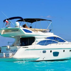Azimut 48 ft Flybridge yacht cruising over turquoise Caribbean waters in Cancún with guests relaxing on deck – I Live Where You Vacation | Yate Azimut 48 pies Flybridge navegando sobre aguas turquesa del Caribe en Cancún con huéspedes relajándose en cubierta – I Live Where You Vacation