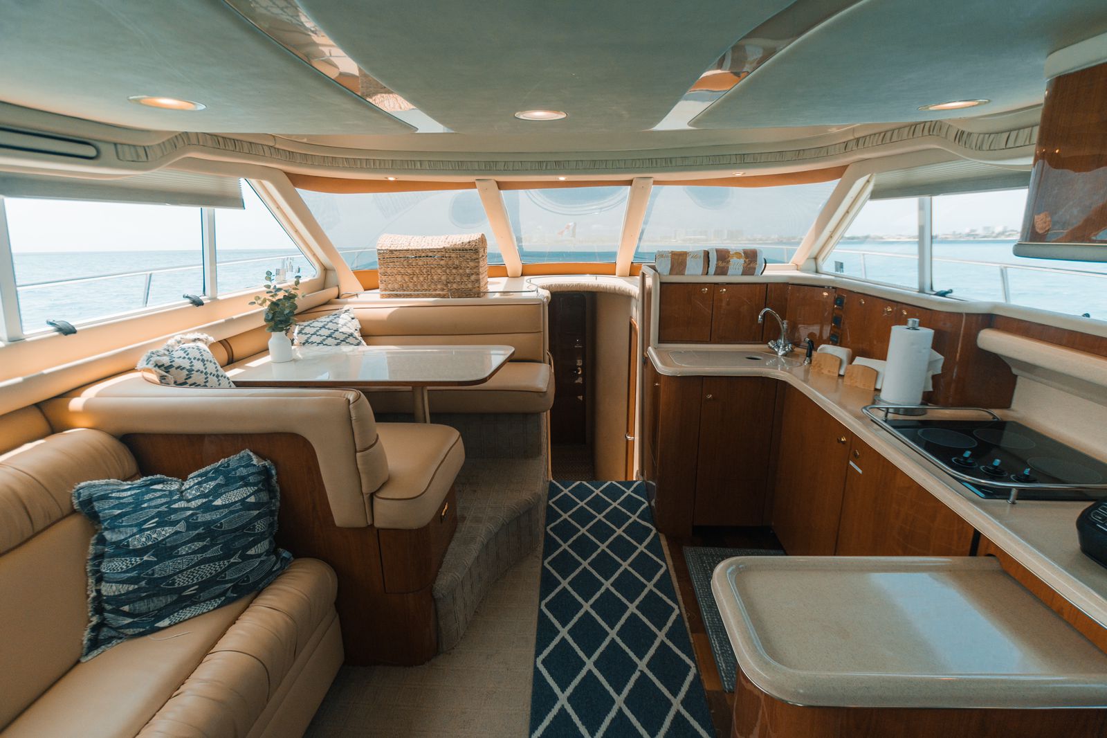 Enjoy comfort and style inside the 52 ft Sea Ray “Sea Mami,” featuring panoramic windows, full galley, and luxury lounge seating. | Disfruta de la comodidad y el estilo a bordo del Sea Ray “Sea Mami” de 52 pies, con ventanas panorámicas, cocina completa y sala de lujo.