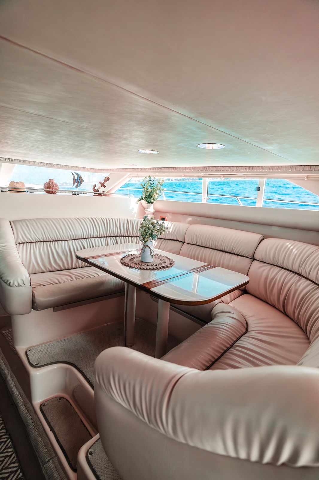 Luxury flybridge helm with a handcrafted captain’s chair, teak-style deck, and panoramic Caribbean views. | Timón flybridge de lujo con asiento de capitán artesanal, piso estilo teca y vistas panorámicas al Caribe.