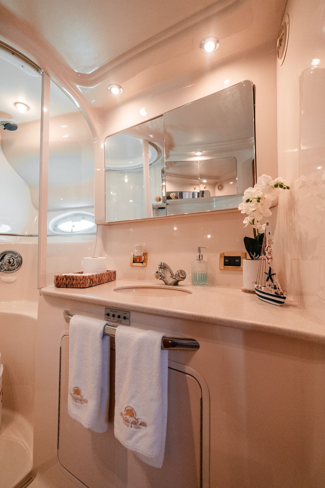 Refined vanity area with soft lighting, mirror, and elegant nautical details. | Tocador refinado con iluminación suave, espejo y elegantes detalles náuticos.
