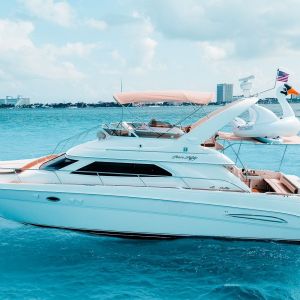 Sea Monkey 50 ft Sea Ray yacht in Cancun with turquoise Caribbean water and skyline view – I Live Where You Vacation | Yate Sea Monkey de 50 pies Sea Ray en Cancún con vista al mar Caribe y horizonte urbano – I Live Where You Vacation