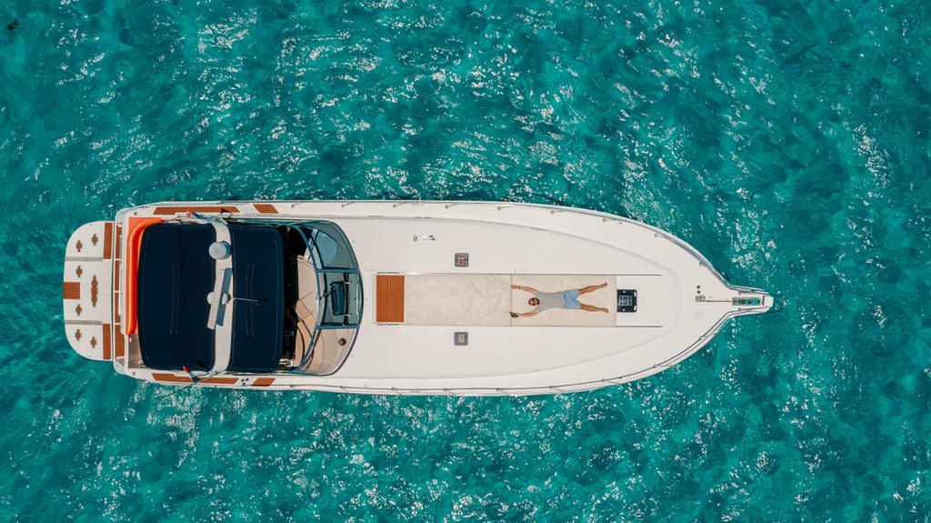 An overhead view of the Sin Nombre 55 ft yacht anchored in the clear Caribbean Sea — pure freedom at sea. | Vista aérea del yate Sin Nombre 55 ft anclado en el mar Caribe — pura libertad en el mar.
