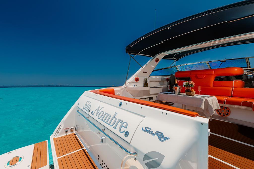 A stylish view of the Sin Nombre 55 ft Sea Ray yacht in Cancún, featuring a refined deck lounge with champagne service. | Vista elegante del yate Sin Nombre 55 ft Sea Ray en Cancún, con una terraza refinada y servicio de champaña.
