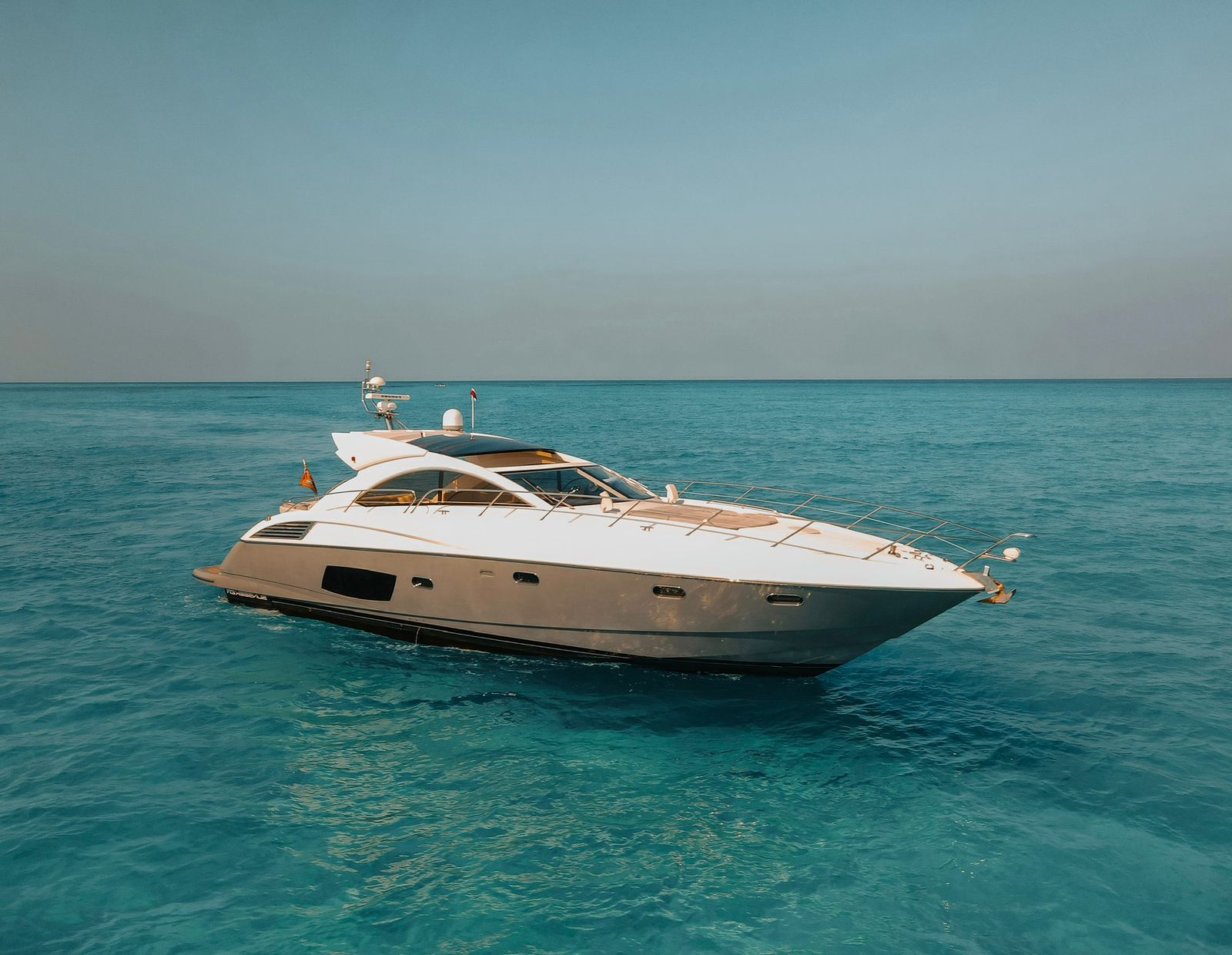 A vision of calm and sophistication — the Tatabu 64 ft Sunseeker rests effortlessly over crystal-clear Caribbean waters. | Una visión de calma y sofisticación — el Tatabu Sunseeker de 64 pies reposa con elegancia sobre las aguas cristalinas del Caribe.
