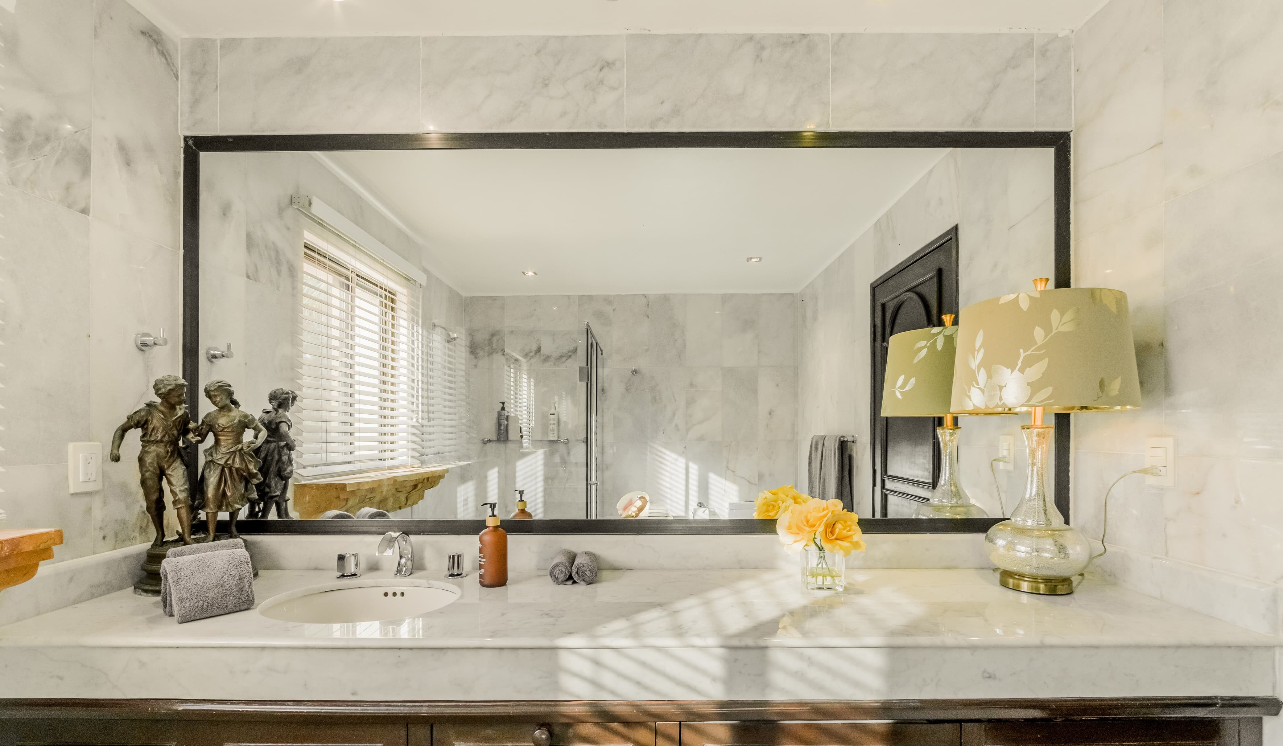 Refined marble bathroom with soft lighting and classic details — Villa Albatros, part of I Live Where You Vacation’s Riviera Maya luxury collection. | Baño de mármol refinado con iluminación suave y detalles clásicos — Villa Albatros, parte de la colección de lujo Riviera Maya de I Live Where You Vacation.
