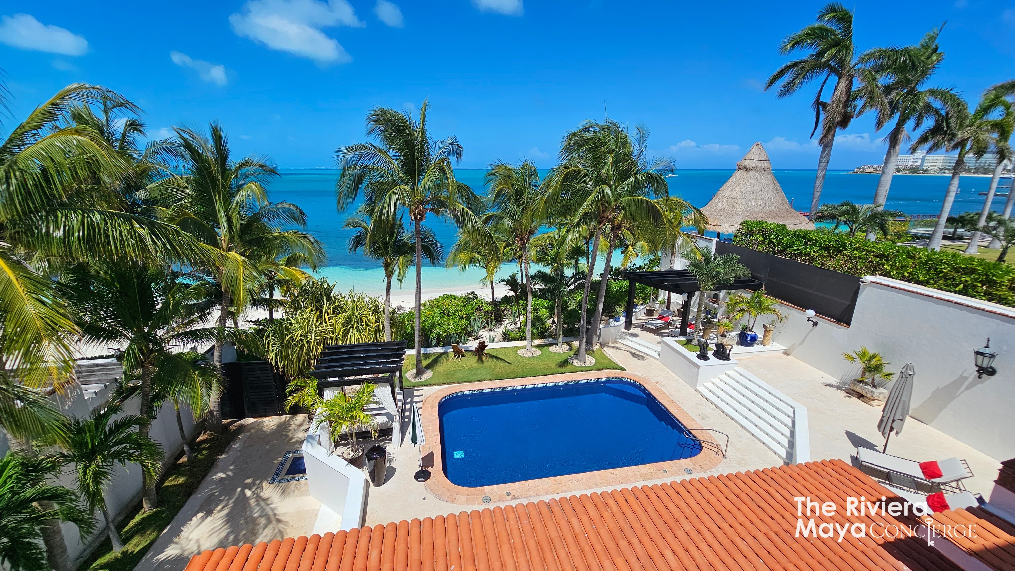 Aerial oceanfront view of Villa Albatros with turquoise sea, private pool and palm-lined garden — part of I Live Where You Vacation’s Riviera Maya luxury collection. | Vista aérea frente al mar de Villa Albatros con mar turquesa, alberca privada y jardín con palmeras — parte de la colección de lujo Riviera Maya de I Live Where You Vacation.
