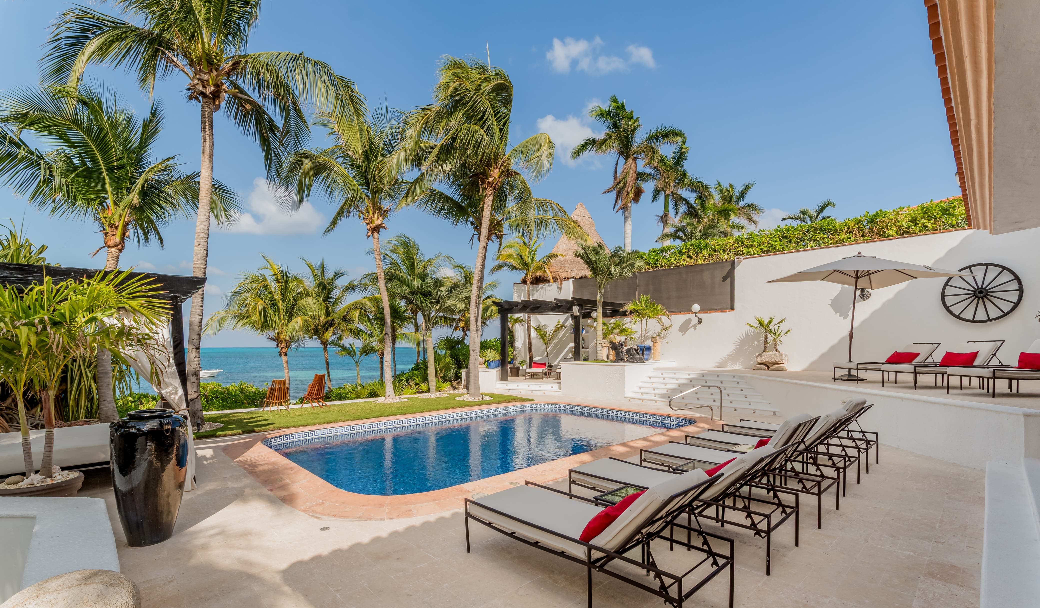 Private oceanview pool surrounded by palm trees — Villa Albatros, part of I Live Where You Vacation’s Riviera Maya luxury collection. | Alberca privada con vista al mar rodeada de palmeras — Villa Albatros, parte de la colección de lujo Riviera Maya de I Live Where You Vacation.
