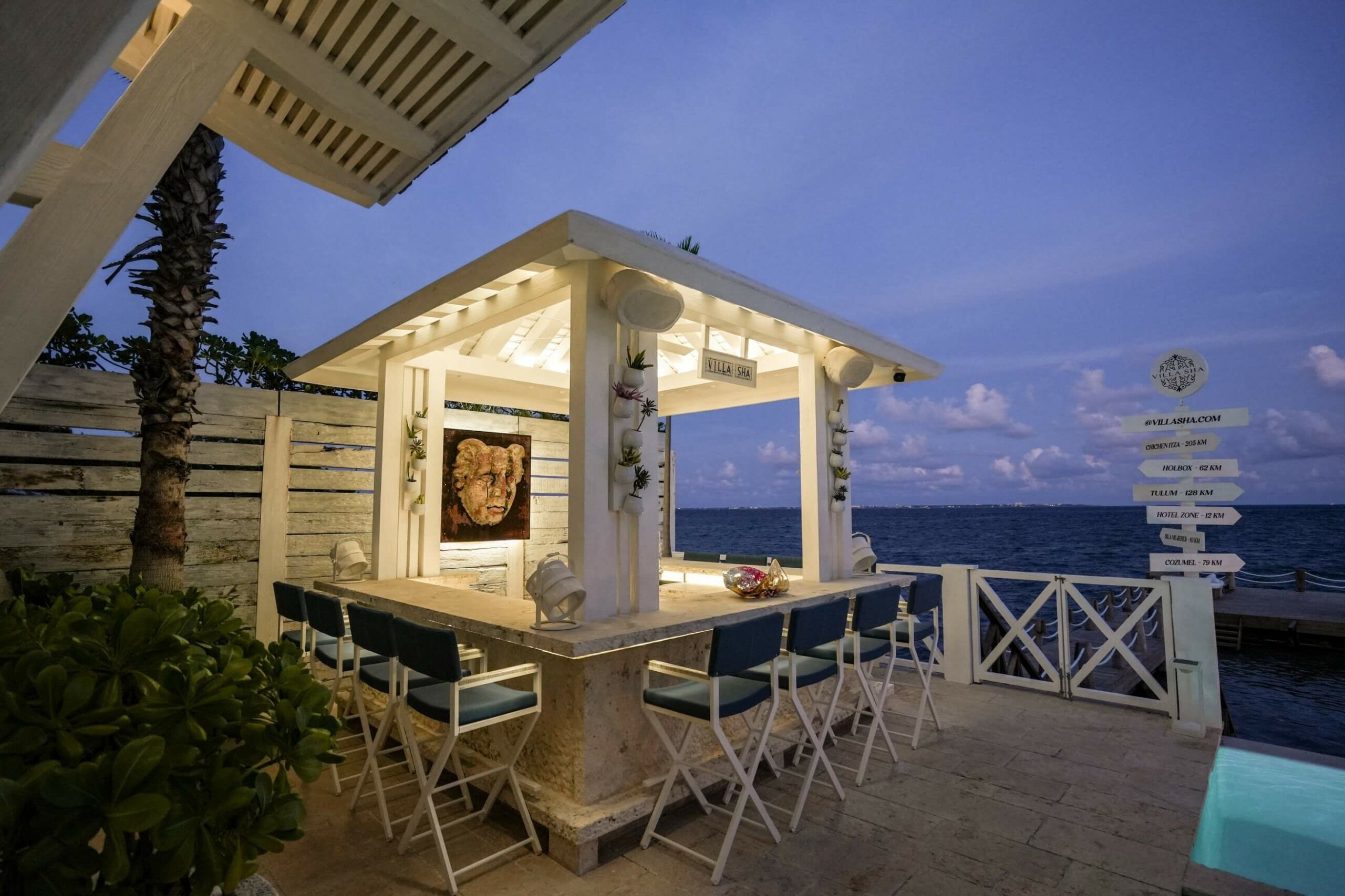 Sip, relax, and watch the sun set from Villa Sha’s private ocean bar — where the Caribbean breeze meets contemporary elegance. | Disfruta, relájate y contempla el atardecer desde la barra privada frente al mar de Villa Sha — donde la brisa caribeña se encuentra con la elegancia contemporánea.
