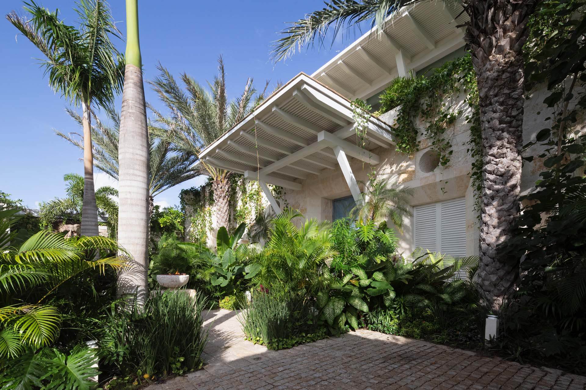 Surrounded by palm trees and lush tropical gardens, Villa Sha blends architectural elegance with the natural beauty of Cancun — curated by I Live Where You Vacation. | Rodeada de palmeras y jardines tropicales, Villa Sha combina elegancia arquitectónica con la belleza natural de Cancún — una experiencia curada por I Live Where You Vacation.
