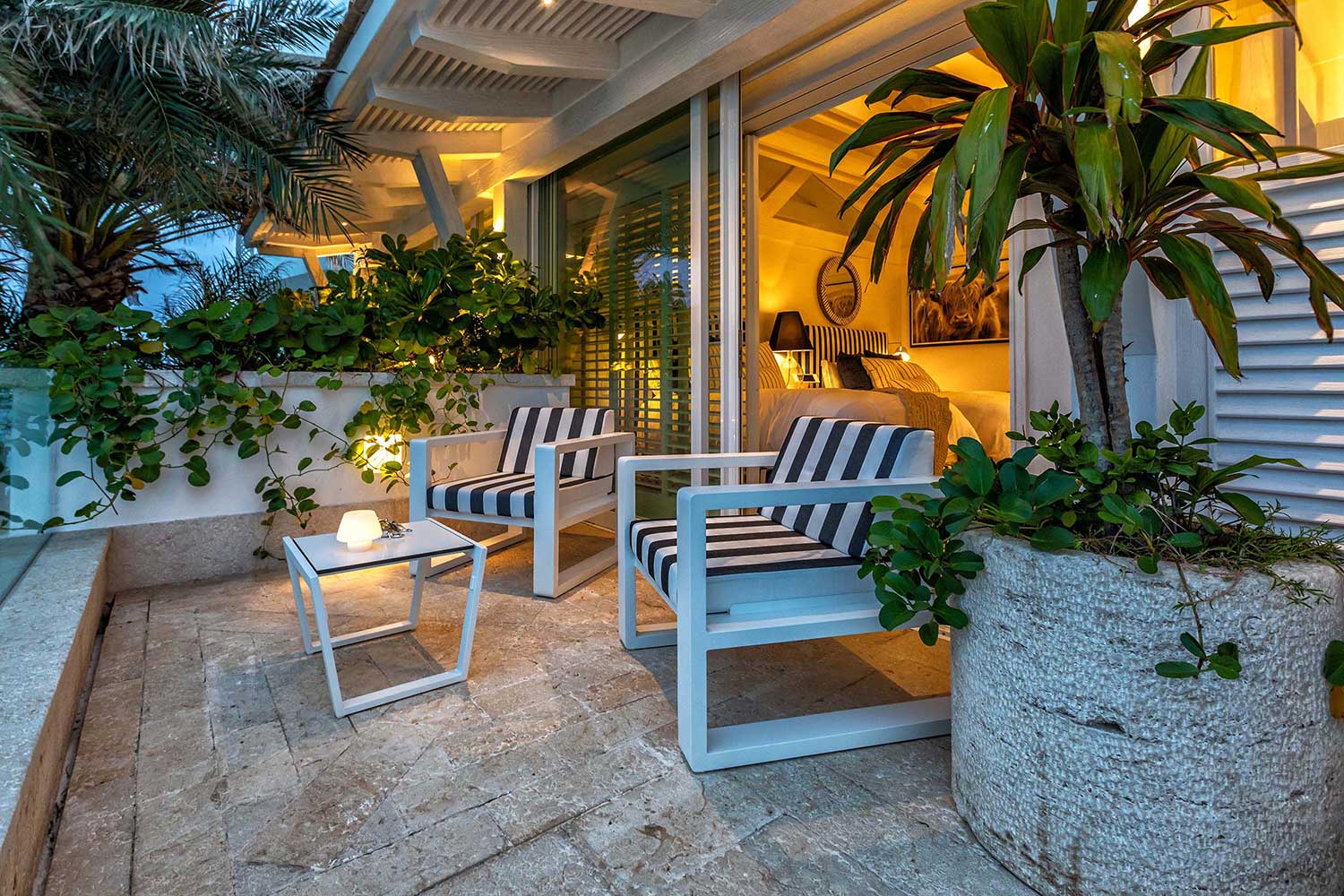 Relaxing terrace that connects indoor elegance with outdoor Caribbean beauty. | Terraza relajante que conecta la elegancia interior con la belleza caribeña exterior.
