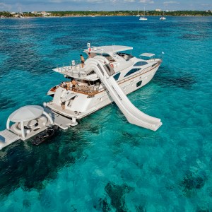 Azimut 80 Flybridge luxury yacht with water slide and floating lounge in turquoise Caribbean waters – I Live Where You Vacation. | Yate de lujo Azimut 80 Flybridge con resbaladilla y lounge flotante en aguas turquesas del Caribe – I Live Where You Vacation.