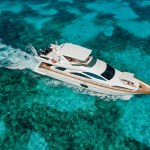 Aerial view of Azimut 80 Flybridge luxury yacht sailing over turquoise Caribbean waters near Cancún – I Live Where You Vacation. | Vista aérea del yate de lujo Azimut 80 Flybridge navegando sobre aguas turquesas del Caribe cerca de Cancún – I Live Where You Vacation.