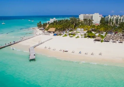 Aerial view of Playa Norte, Isla Mujeres – turquoise Caribbean waters, white sand beach, and palm trees by I Live Where You Vacation. | Vista aérea de Playa Norte en Isla Mujeres – aguas turquesas del Caribe, playa de arena blanca y palmeras por I Live Where You Vacation.
