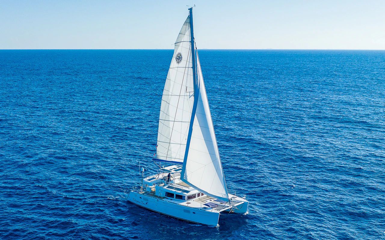 The Blue Iris is captured gliding smoothly across the deep blue waters near Puerto Aventuras, its modern catamaran design radiating refinement and comfort. The setting evokes an atmosphere of exclusivity, where open decks, curated service, and gourmet onboard amenities elevate the experience. Crafted for travellers seeking sophistication on the water, it embodies the essence of Riviera Maya luxury. Keywords: luxury catamaran, Caribbean sailing, Puerto Aventuras yacht, Riviera Maya luxury, private charter Mexico.
