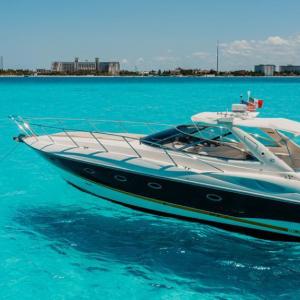 Agavero 44ft Sunseeker-style yacht on turquoise water in Cancún, full exterior view — Yate Agavero 44ft estilo Sunseeker sobre agua turquesa en Cancún, vista exterior completa