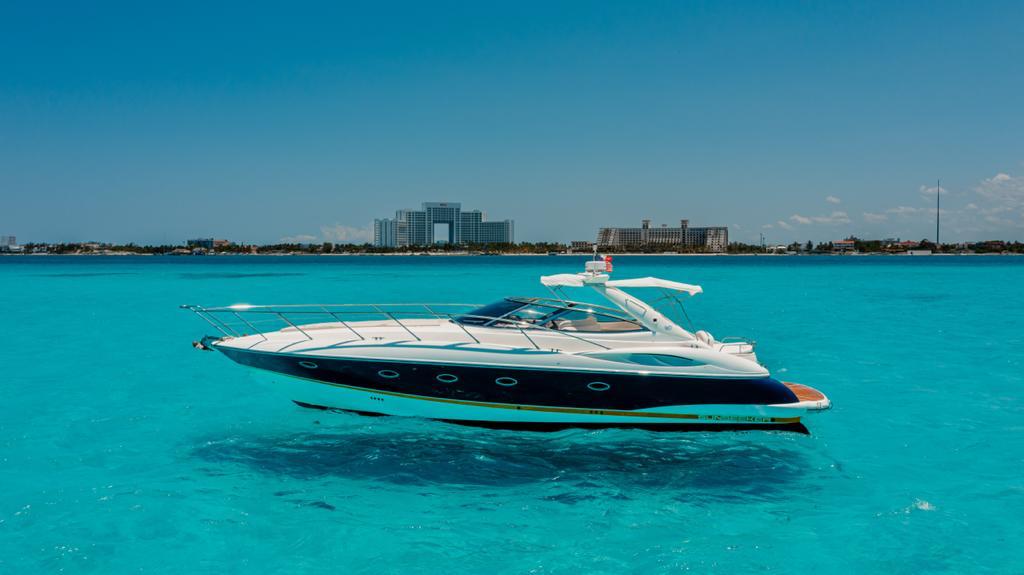Full side profile of Agavero 44ft Sunseeker-style yacht over Cancun Caribbean water