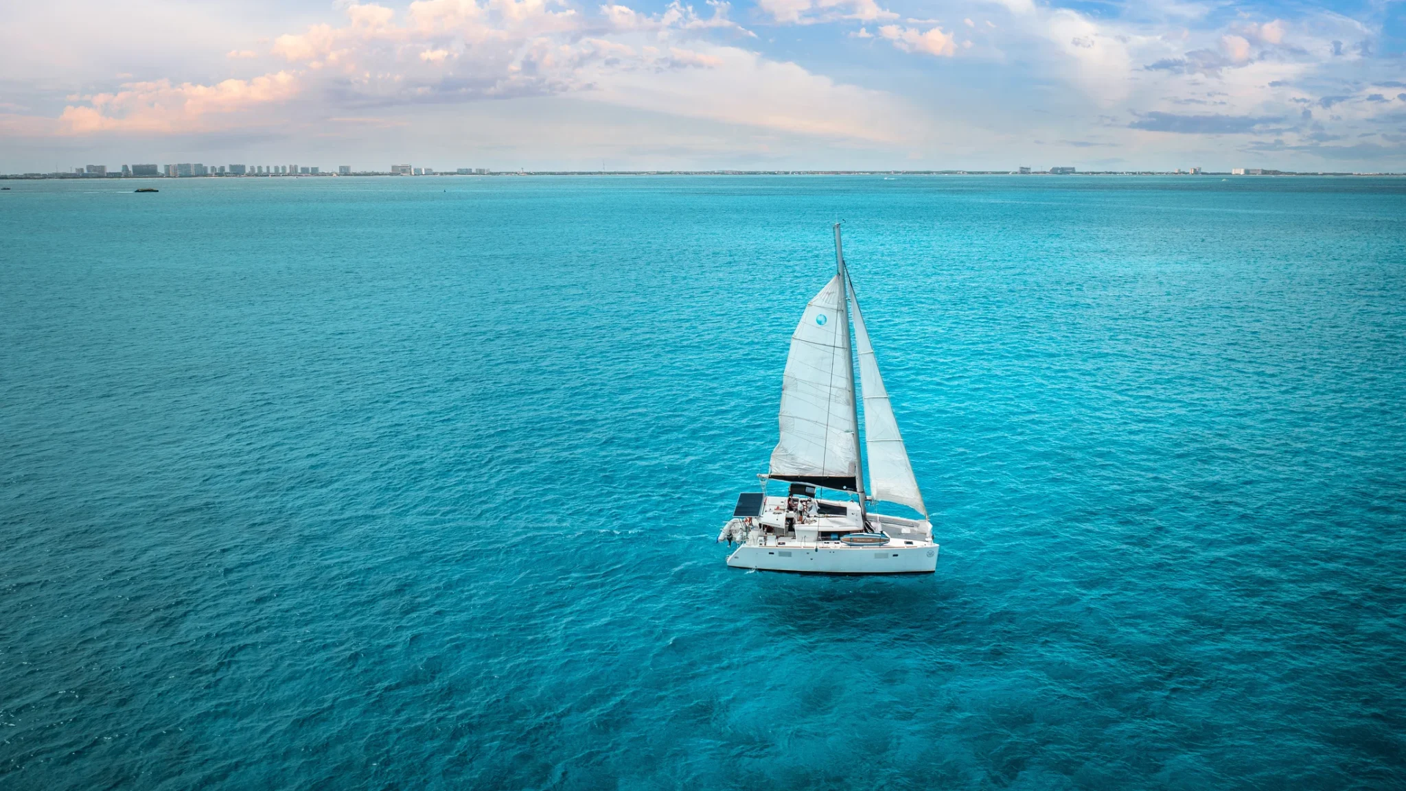 Beluga Catamaran sailing across turquoise Caribbean waters in Cancun