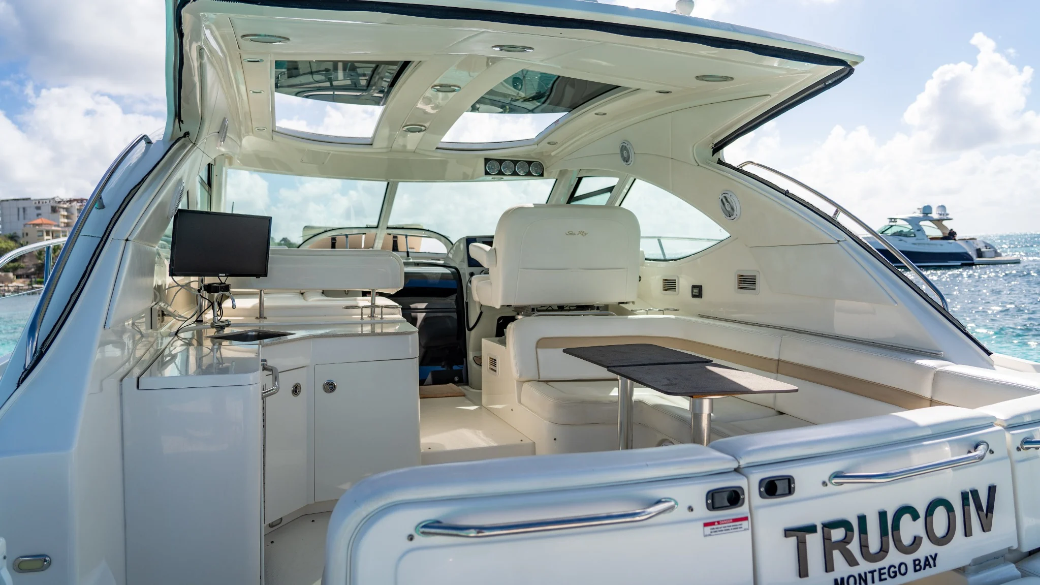 Truco IV 47ft aft cockpit lounge with shaded seating and sea view