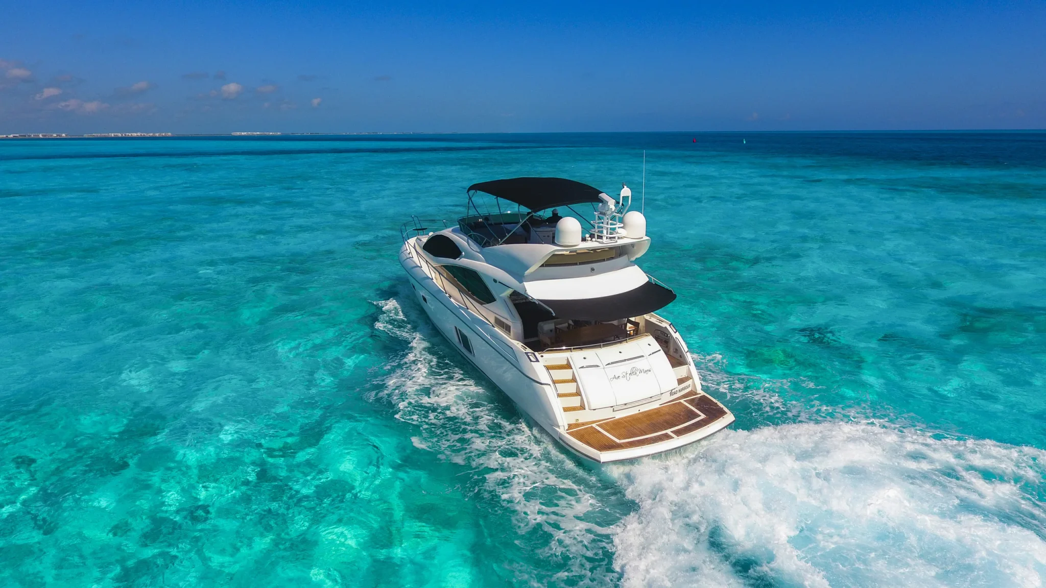 Ave Stella 64ft Sunseeker private yacht charter in Cancun showing aerial stern-quarter cruising view.