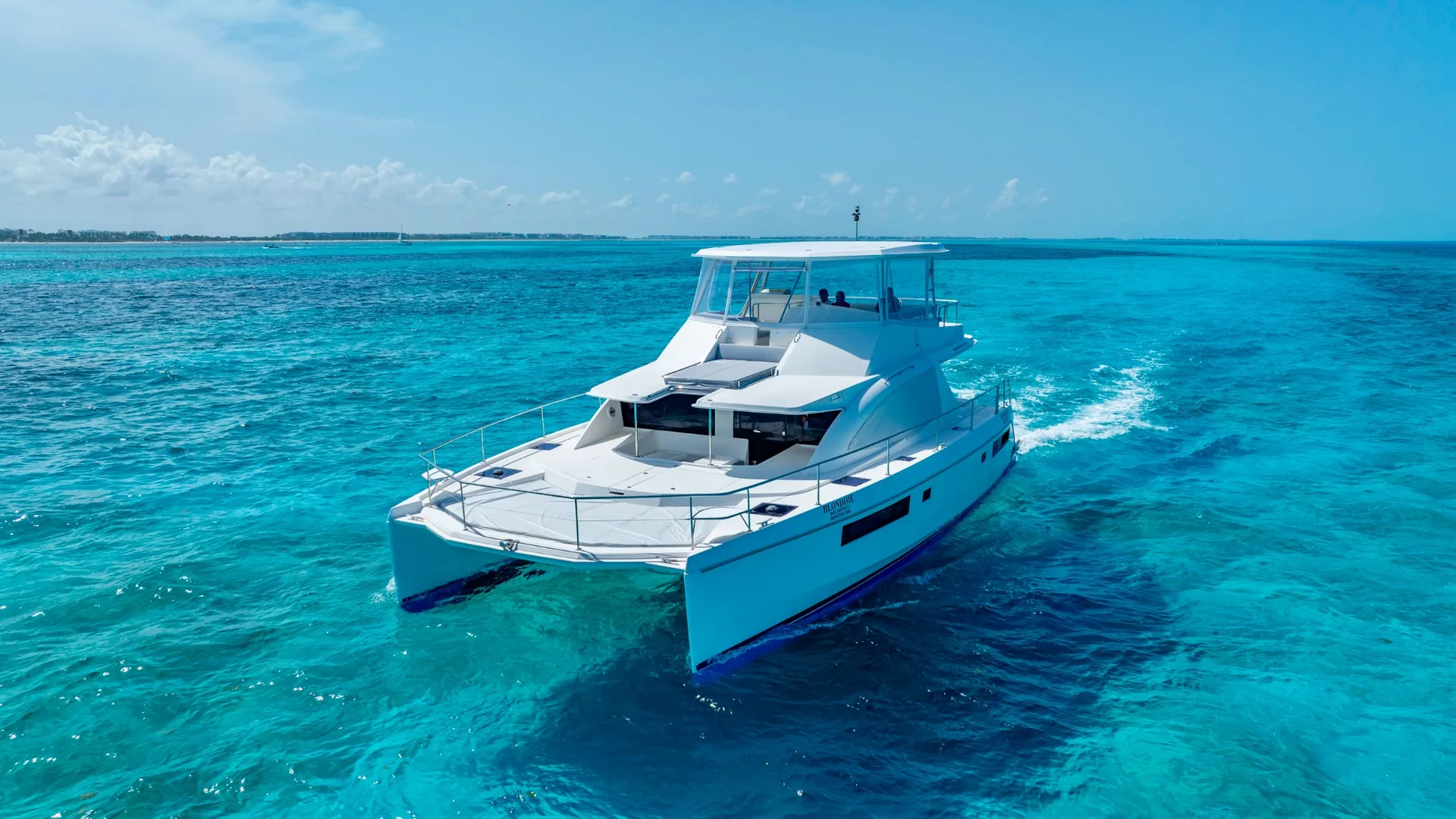 Blondie 51ft Leopard aerial bow cruising over turquoise water in Cancun