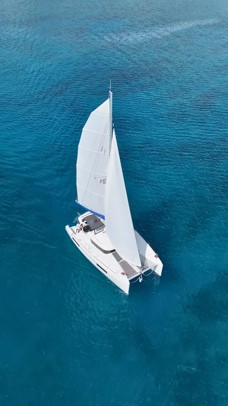 Aerial view of Blue Iris 40ft Lagoon Catamaran sailing over Riviera Maya open water.