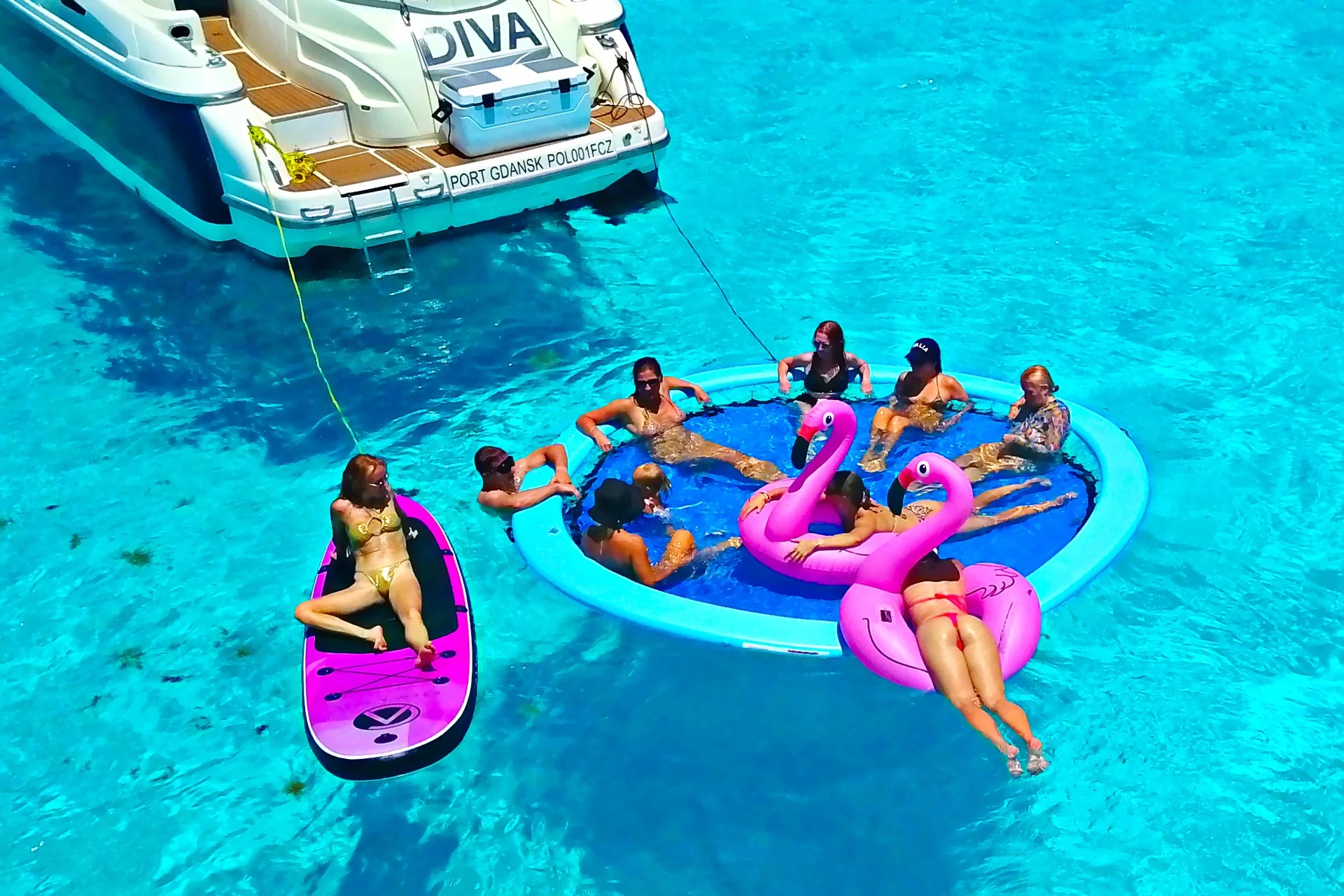 Guests enjoying floating water toys beside Diva 60ft yacht in Cancun