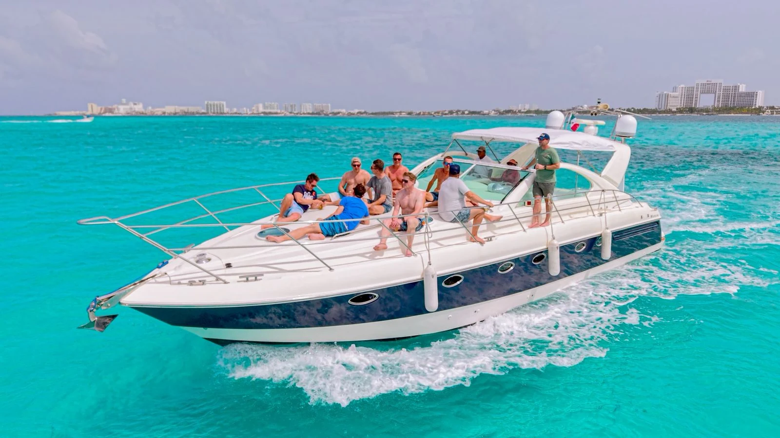 Nash 52ft Fairline yacht cruising across Cancun’s turquoise Caribbean water with guests relaxing on deck.