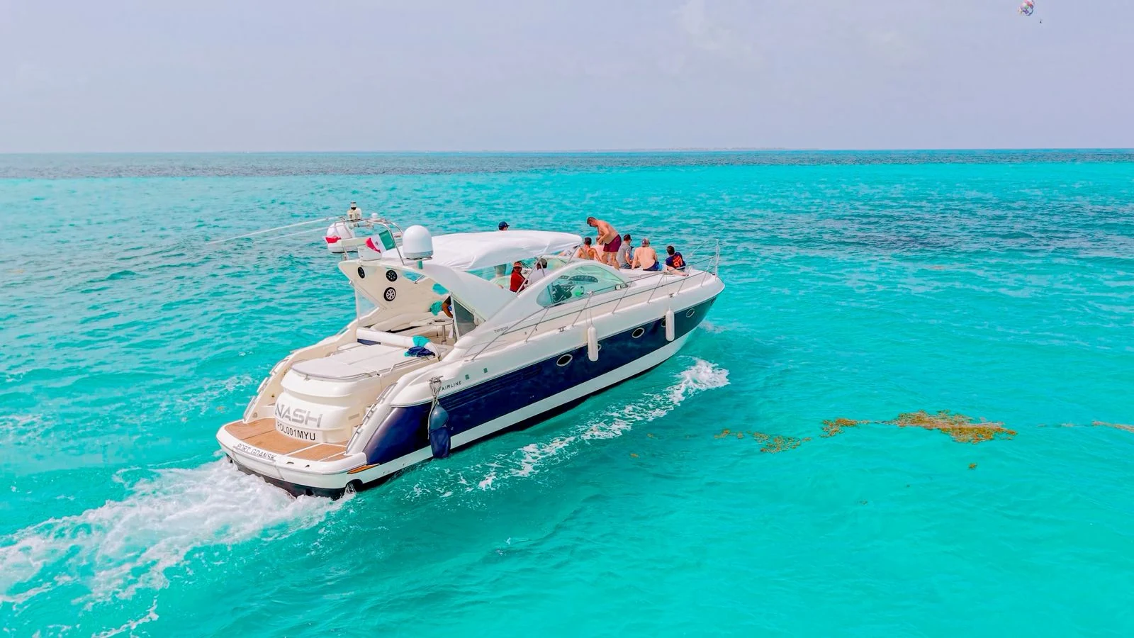 The Nash 52ft yacht cruising over bright turquoise water with Cancun’s Caribbean scenery in the background.