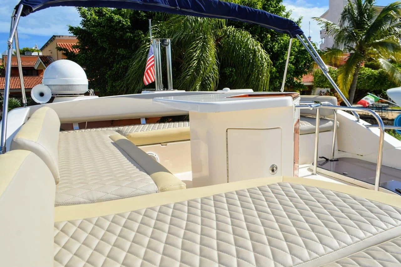 Tatich 48ft private yacht flybridge lounge with quilted seating and shaded social area in Cancun