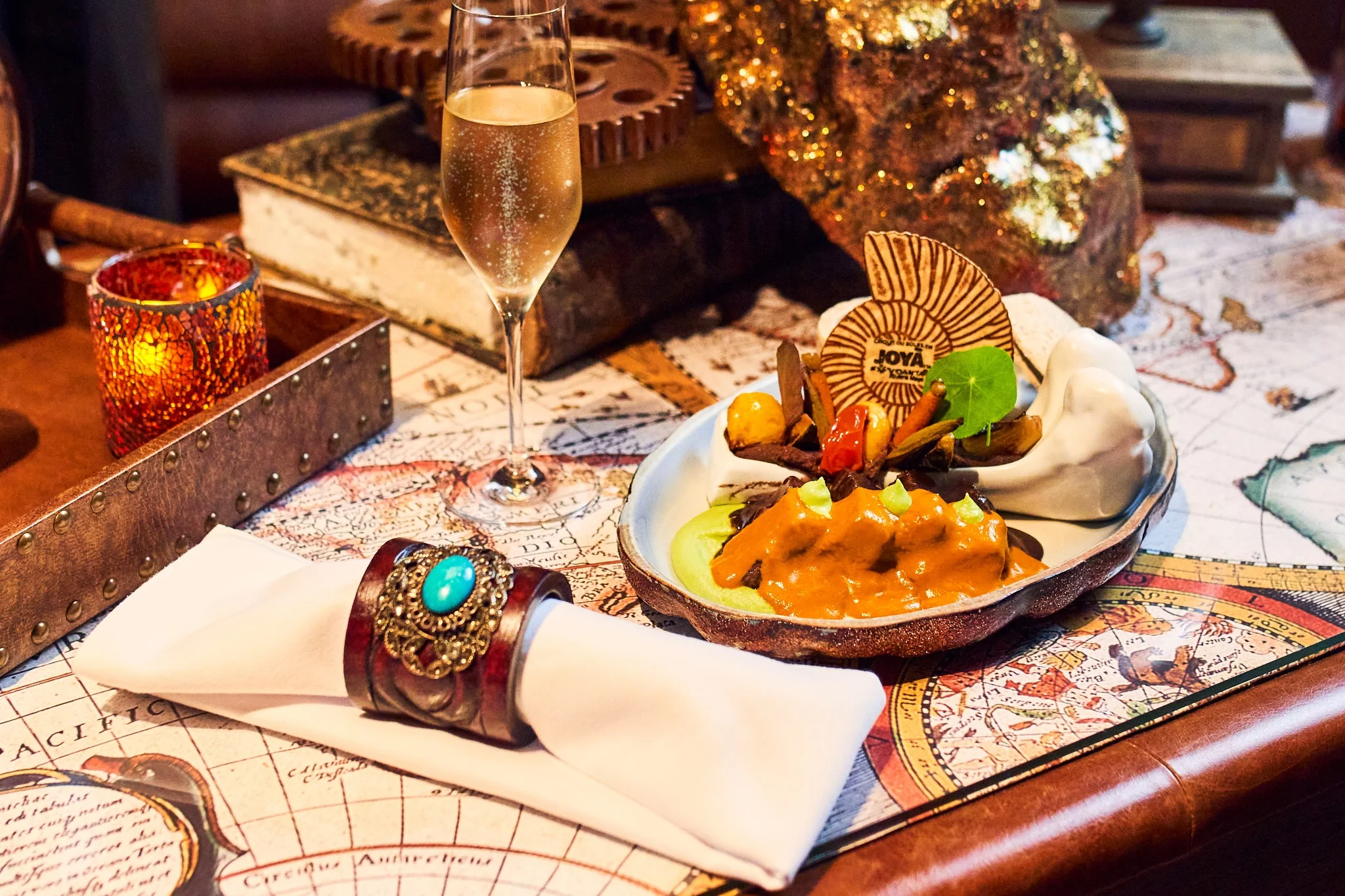 JOYÀ gourmet main course served with champagne in the immersive dining theatre